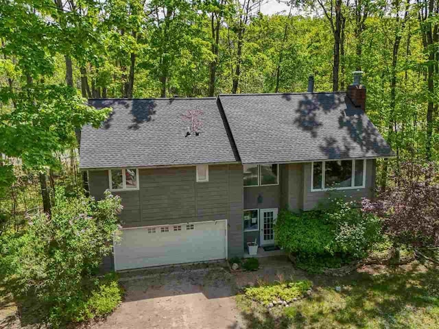 104 Meadow Wood Dr, Harbor Springs, MI 49740 - view of front of house with a shingled roof and a chimney