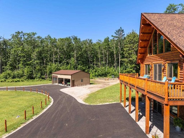899 S State Rd, Harbor Springs, MI 49740 - view of property exterior featuring a lawn, a detached garage, log siding, and an outdoor structure