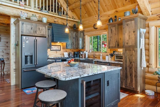 899 S State Rd, Harbor Springs, MI 49740 - kitchen with high end refrigerator, rustic walls, beverage cooler, wooden ceiling, and extractor fan