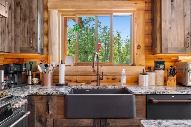 899 S State Rd, Harbor Springs, MI 49740 - kitchen featuring stainless steel range with gas stovetop, dishwasher, light stone countertops, and log walls