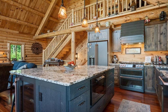 899 S State Rd, Harbor Springs, MI 49740 - kitchen with premium appliances, beverage cooler, log walls, ventilation hood, and open floor plan