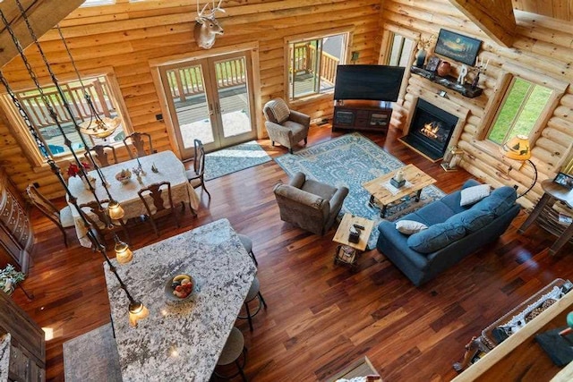 899 S State Rd, Harbor Springs, MI 49740 - living area featuring log walls, wood finished floors, plenty of natural light, a fireplace with flush hearth, and french doors