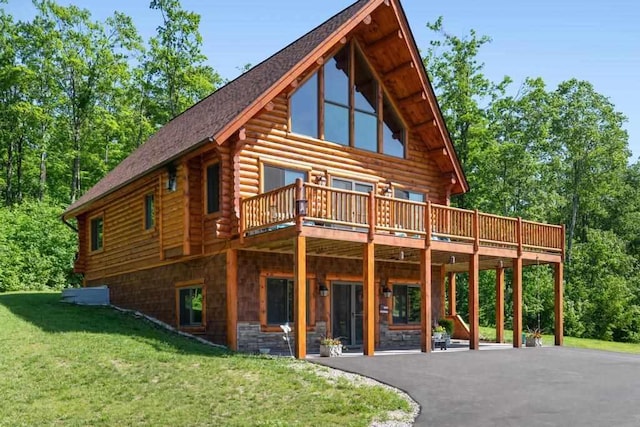 899 S State Rd, Harbor Springs, MI 49740 - view of front of home with log siding, a front lawn, a deck, stone siding, and driveway