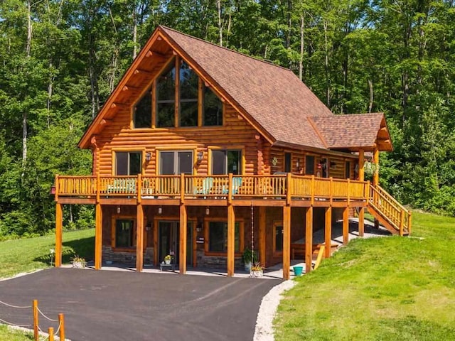 899 S State Rd, Harbor Springs, MI 49740 - cabin with log exterior, a front yard, a deck, and driveway