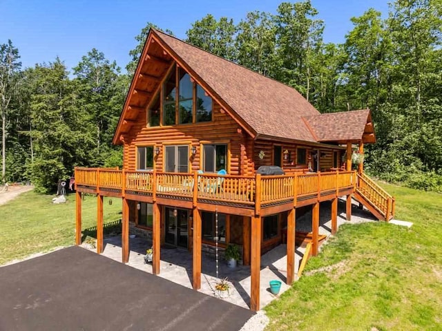 899 S State Rd, Harbor Springs, MI 49740 - back of house featuring log exterior, a patio, a yard, a wooden deck, and roof with shingles