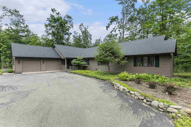1835 Bluffs Edge, Harbor Springs, MI 49740 - single story home with an attached garage, driveway, and roof with shingles