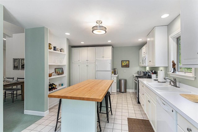 1835 Bluffs Edge, Harbor Springs, MI 49740 - kitchen featuring white appliances, a kitchen bar, white cabinetry, wooden counters, and light tile patterned flooring