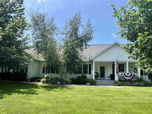 7570 Bay Meadow Dr, Harbor Springs, MI 49740 - view of front of home featuring covered porch, a front lawn, and roof with shingles