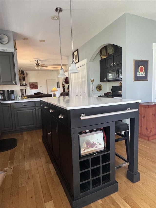 7570 Bay Meadow Dr, Harbor Springs, MI 49740 - kitchen featuring black microwave, light wood-type flooring, light countertops, ceiling fan, and open floor plan
