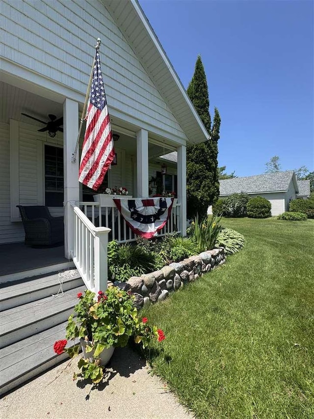7570 Bay Meadow Dr, Harbor Springs, MI 49740 - view of property exterior featuring a porch, a yard, and ceiling fan