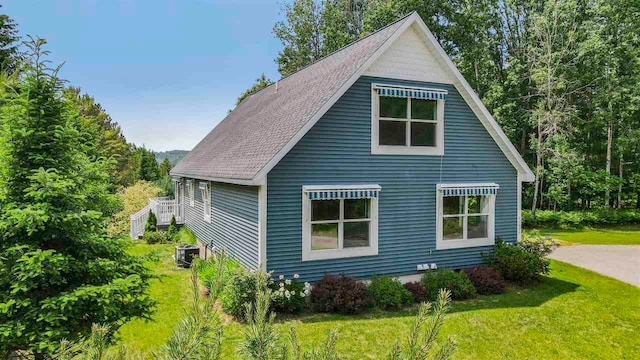 1885 Lalonde Rd, East Jordan, MI 49727 - view of side of home featuring a lawn and a central air condition unit