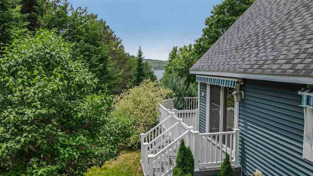 1885 Lalonde Rd, East Jordan, MI 49727 - view of side of home with a shingled roof, stairway, and a deck