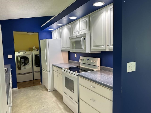 4505 S State Rd, Harbor Springs, MI 49740 - kitchen featuring white appliances, independent washer and dryer, dark countertops, recessed lighting, and white cabinetry