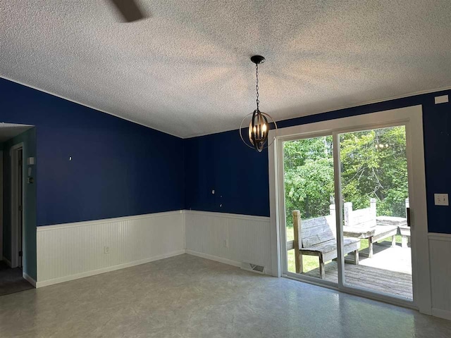 4505 S State Rd, Harbor Springs, MI 49740 - spare room with a wainscoted wall, a textured ceiling, and a chandelier