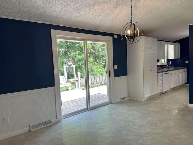 4505 S State Rd, Harbor Springs, MI 49740 - kitchen with white dishwasher, a textured ceiling, wainscoting, a chandelier, and dark countertops