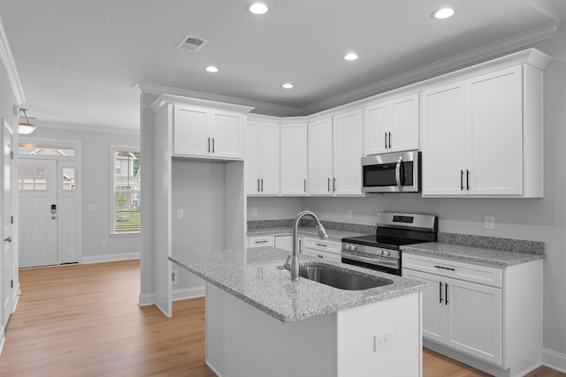 3320 Navin Trl, Roebuck, SC 29376 - kitchen featuring appliances with stainless steel finishes, ornamental molding, white cabinets, an island with sink, and recessed lighting