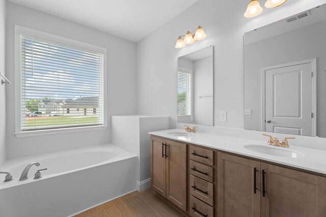 3320 Navin Trl, Roebuck, SC 29376 - full bathroom featuring double vanity, a bath, and wood finished floors