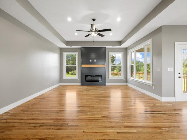 708 Mello Dr, Lyman, SC 29365 - unfurnished living room with wood finished floors, a ceiling fan, a tray ceiling, a fireplace, and recessed lighting
