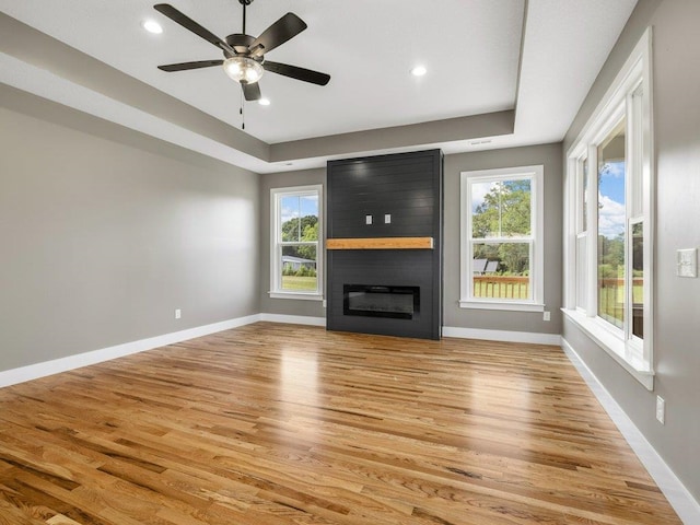 708 Mello Dr, Lyman, SC 29365 - unfurnished living room with light wood-style flooring, a fireplace, a raised ceiling, a ceiling fan, and recessed lighting