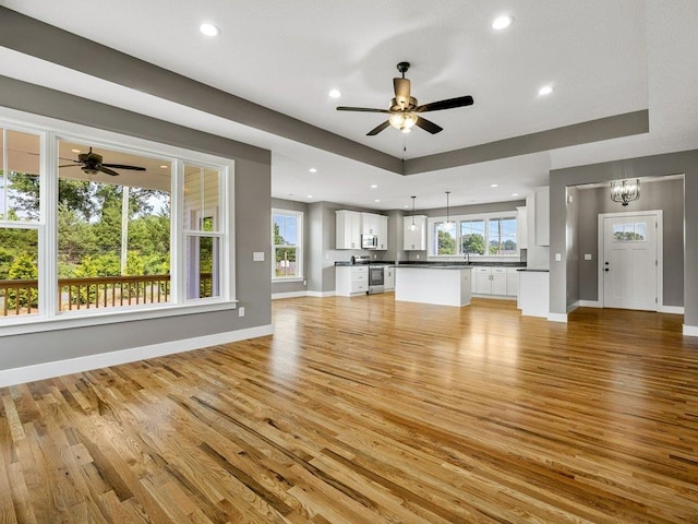 708 Mello Dr, Lyman, SC 29365 - unfurnished living room featuring ceiling fan, light wood finished floors, recessed lighting, and a tray ceiling