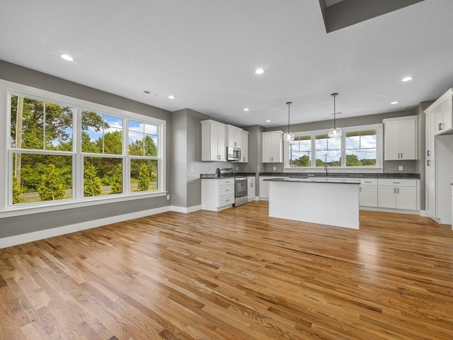 708 Mello Dr, Lyman, SC 29365 - kitchen with stainless steel appliances, dark countertops, light wood-style flooring, recessed lighting, and white cabinetry