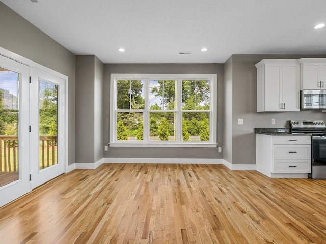 708 Mello Dr, Lyman, SC 29365 - kitchen featuring appliances with stainless steel finishes, light wood-style floors, dark countertops, white cabinets, and recessed lighting