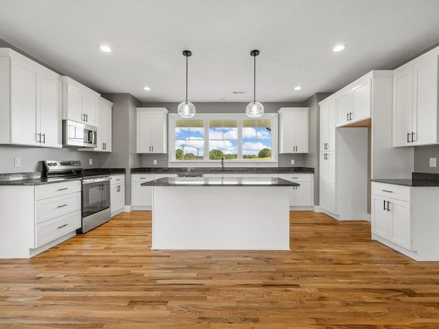 708 Mello Dr, Lyman, SC 29365 - kitchen with stainless steel appliances, dark countertops, light wood-style flooring, white cabinetry, and recessed lighting