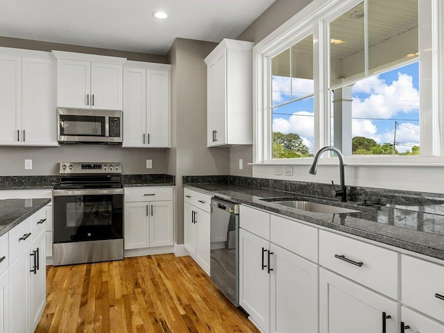 708 Mello Dr, Lyman, SC 29365 - kitchen featuring stainless steel appliances, white cabinetry, light wood finished floors, recessed lighting, and dark stone counters