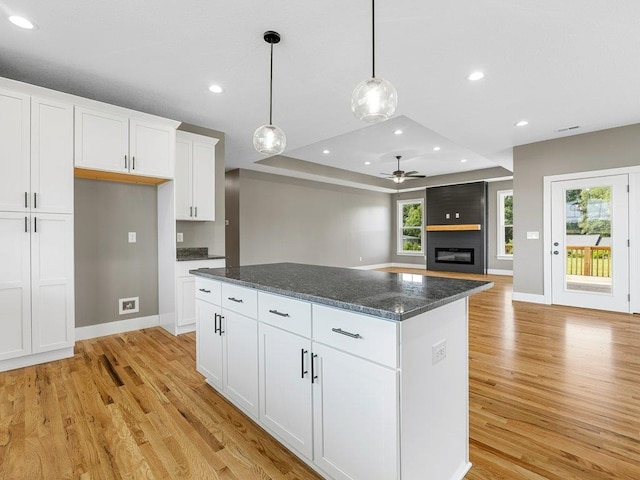 708 Mello Dr, Lyman, SC 29365 - kitchen featuring a ceiling fan, light wood-style floors, a center island, a raised ceiling, and a fireplace