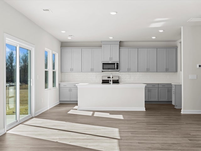 119 Martel Dr, Spartanburg, SC 29301 - kitchen featuring stainless steel microwave, gray cabinetry, healthy amount of natural light, decorative backsplash, and recessed lighting