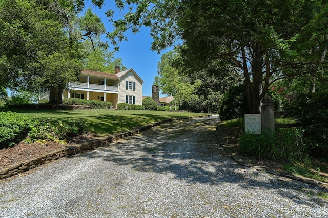 835 Jackson Grove Rd, Columbus, NC 28722 - view of front facade with a chimney, a front yard, gravel driveway, and a balcony