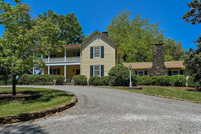 835 Jackson Grove Rd, Columbus, NC 28722 - traditional-style home featuring a balcony, a chimney, a porch, curved driveway, and a front lawn