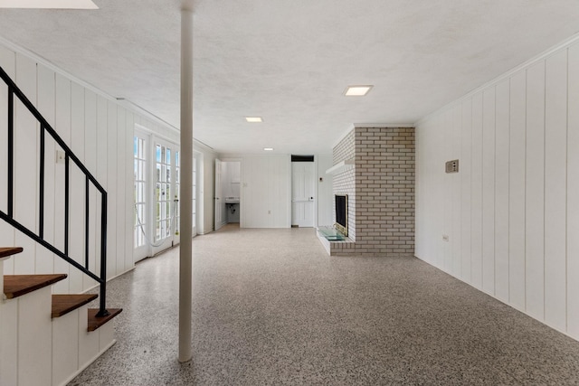 802 Hickory Hollow Rd, Inman, SC 29349 - unfurnished living room featuring speckled floor, stairs, a textured ceiling, a brick fireplace, and crown molding
