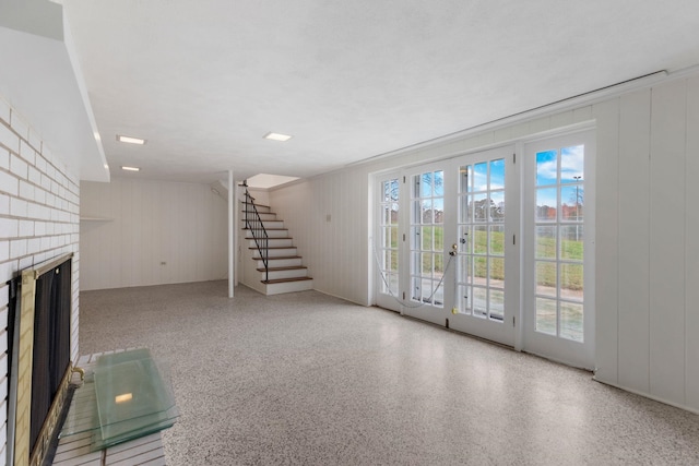 802 Hickory Hollow Rd, Inman, SC 29349 - unfurnished living room with stairway, a brick fireplace, speckle patterned floor, and wood walls