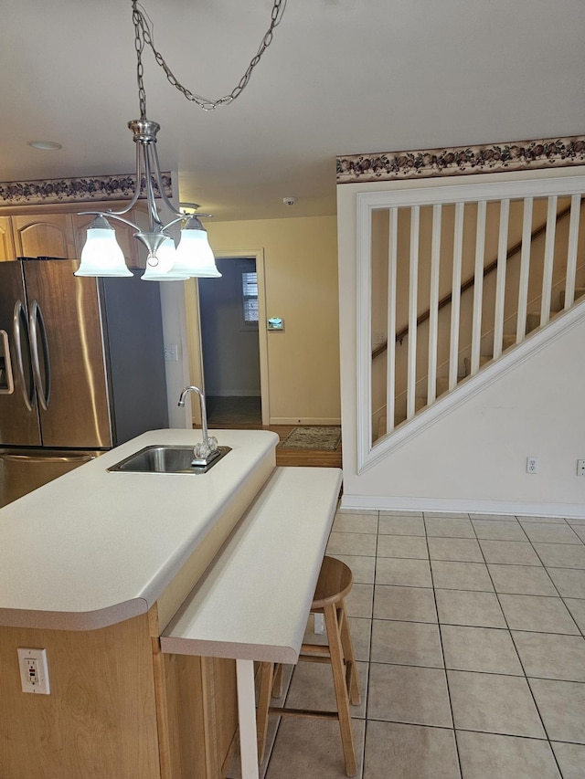 1 Carnoustie Ct, Campobello, SC 29322 - kitchen with freestanding refrigerator, decorative light fixtures, a kitchen island with sink, light tile patterned floors, and light countertops