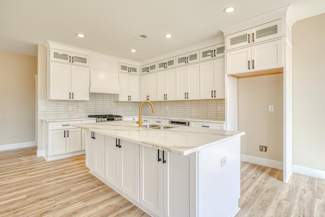 155 Chestnut Dr, Woodruff, SC 29388 - kitchen featuring light wood finished floors, an island with sink, backsplash, light stone countertops, and recessed lighting