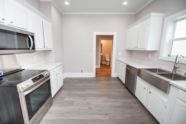 708 E Main St, Union, SC 29379 - kitchen featuring appliances with stainless steel finishes, white cabinets, ornamental molding, light wood-type flooring, and recessed lighting