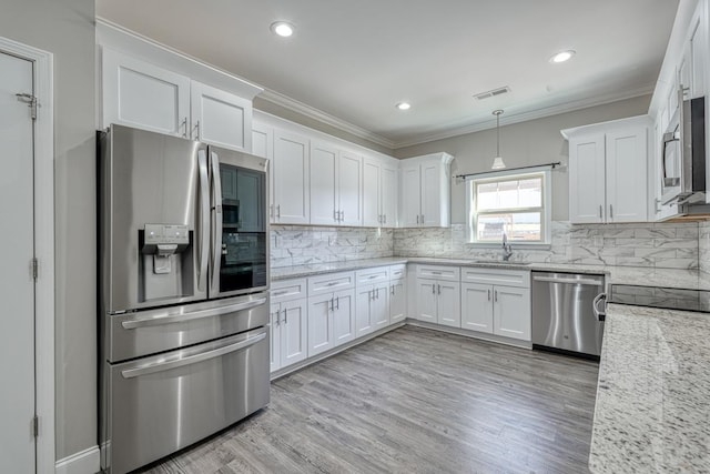139 Floyd Meadow Dr, Inman, SC 29349 - kitchen with appliances with stainless steel finishes, white cabinetry, light wood-type flooring, tasteful backsplash, and light stone countertops