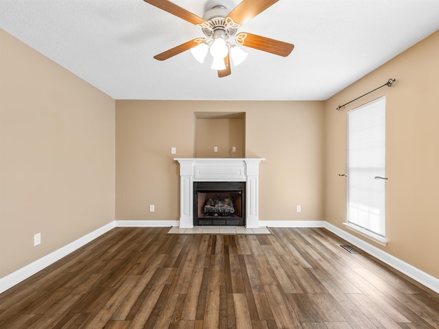 160 Blake Garrison Dr, Roebuck, SC 29376 - unfurnished living room with a fireplace with flush hearth, dark wood finished floors, and ceiling fan