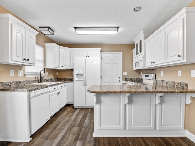 160 Blake Garrison Dr, Roebuck, SC 29376 - kitchen with white appliances, a peninsula, dark wood-style floors, white cabinets, and a textured ceiling