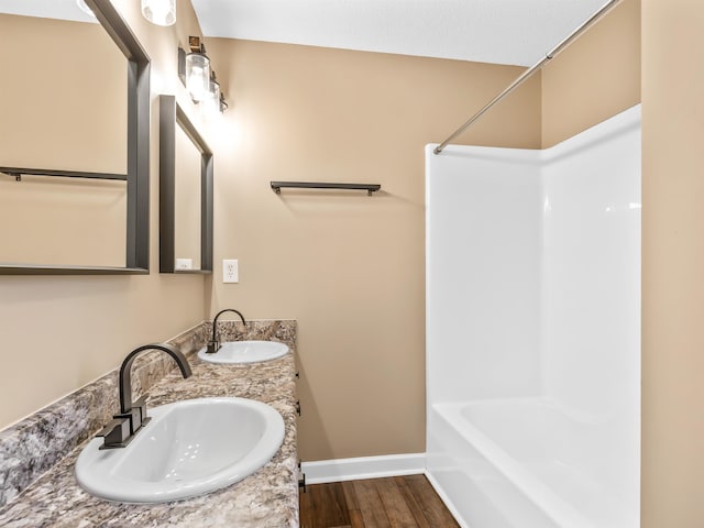 160 Blake Garrison Dr, Roebuck, SC 29376 - full bathroom featuring double vanity, wood finished floors, and shower / bath combination