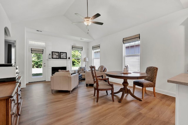 2297 Davenport Ct, Moore, SC 29369 - dining room with vaulted ceiling, light wood-style floors, ceiling fan, and a fireplace