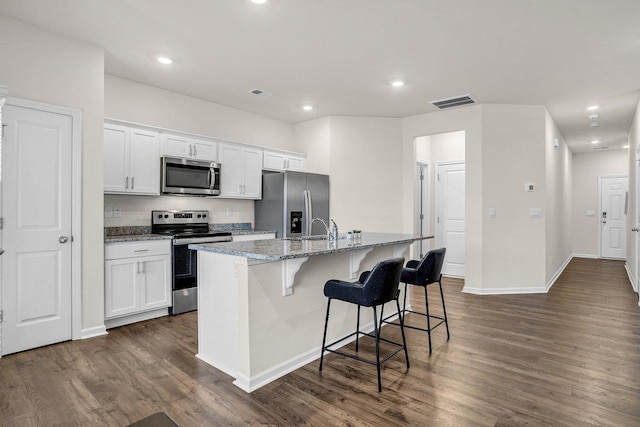 14 Sunriff Ct, Greer, SC 29651 - kitchen with appliances with stainless steel finishes, an island with sink, dark wood-style flooring, white cabinetry, and recessed lighting