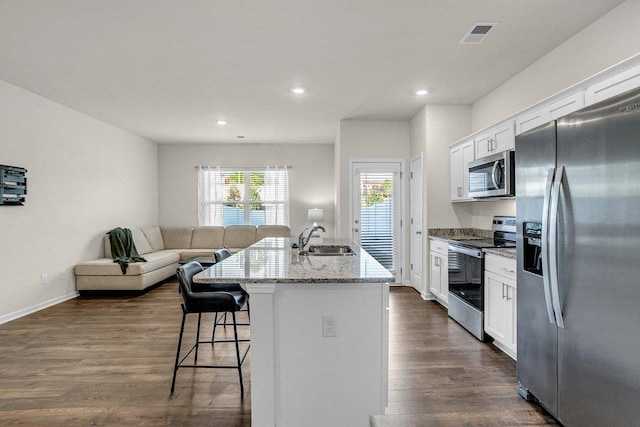 14 Sunriff Ct, Greer, SC 29651 - kitchen with stainless steel appliances, a breakfast bar area, open floor plan, an island with sink, and white cabinets