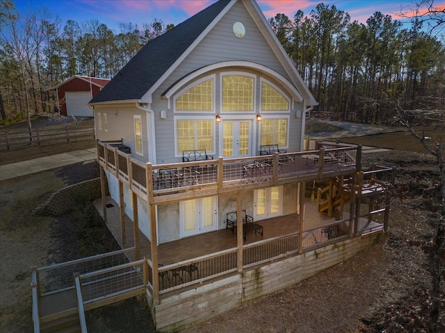 3664 River Rd, Union, SC 29379 - back of property at dusk with french doors, a wooden deck, a shingled roof, and an outbuilding