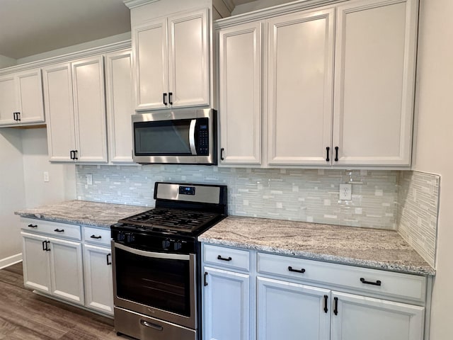 637 Grays Creek Rd, Spartanburg, SC 29303 - kitchen with stainless steel appliances, tasteful backsplash, dark wood-type flooring, and light stone counters