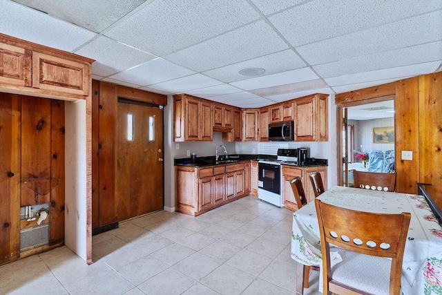 1109 Hemlock Dr, Shelby, NC 28150 - kitchen with electric stove, stainless steel microwave, dark countertops, a paneled ceiling, and light tile patterned floors