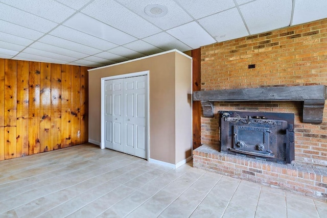 1109 Hemlock Dr, Shelby, NC 28150 - unfurnished living room with a paneled ceiling, wooden walls, tile patterned floors, and a fireplace