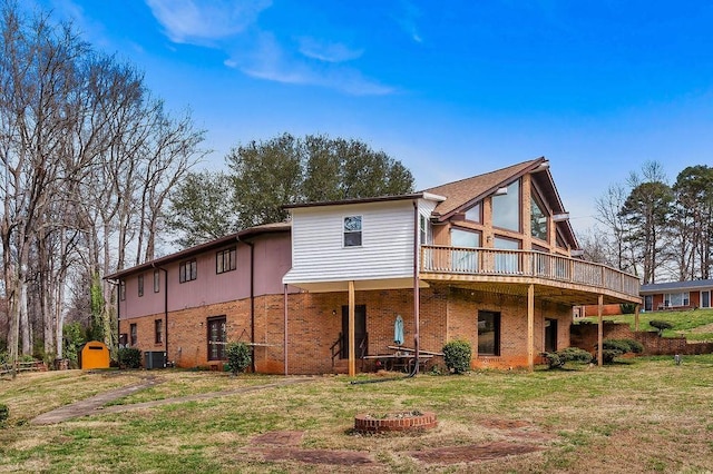 1109 Hemlock Dr, Shelby, NC 28150 - rear view of property featuring brick siding, a wooden deck, a yard, and an outdoor fire pit