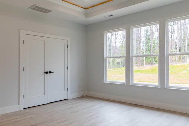 114 Robin Hill Dr, Inman, SC 29349 - unfurnished bedroom with multiple windows, light wood finished floors, and a tray ceiling